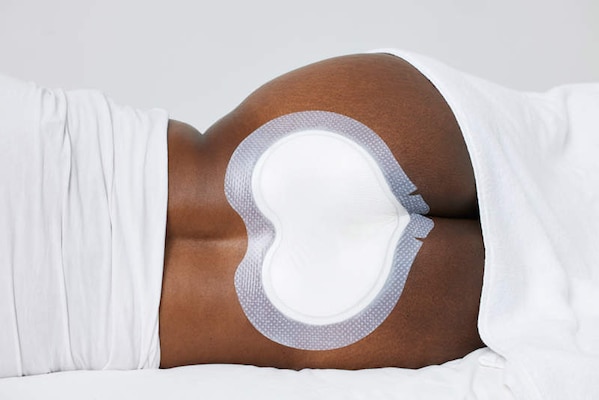 Biatain Silicone Fit large sacral dressing applied to sacral region.